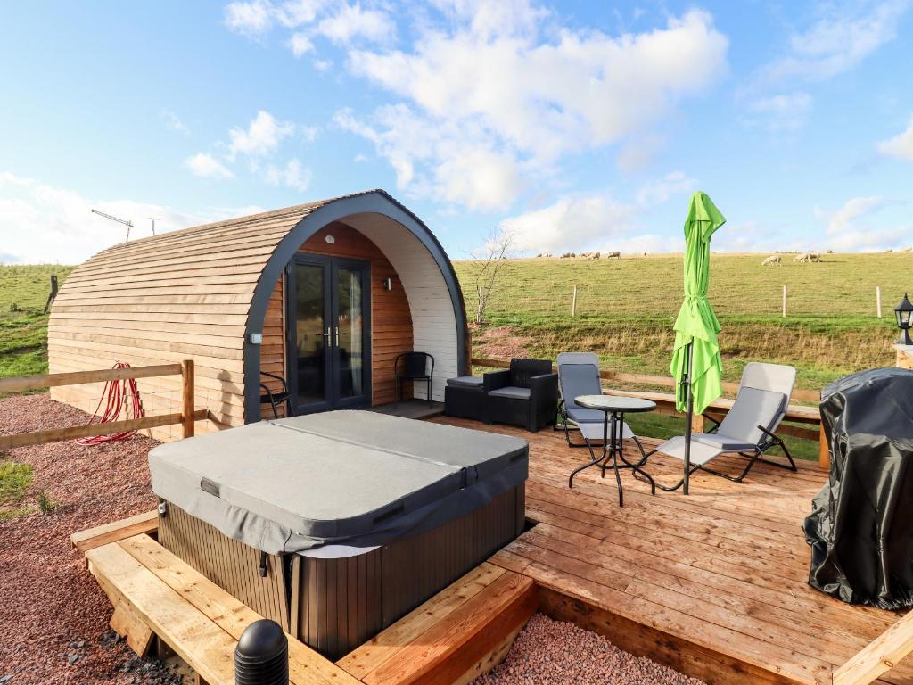 a circular tent with a table and chairs on a wooden deck at Gander Pod in Worcester