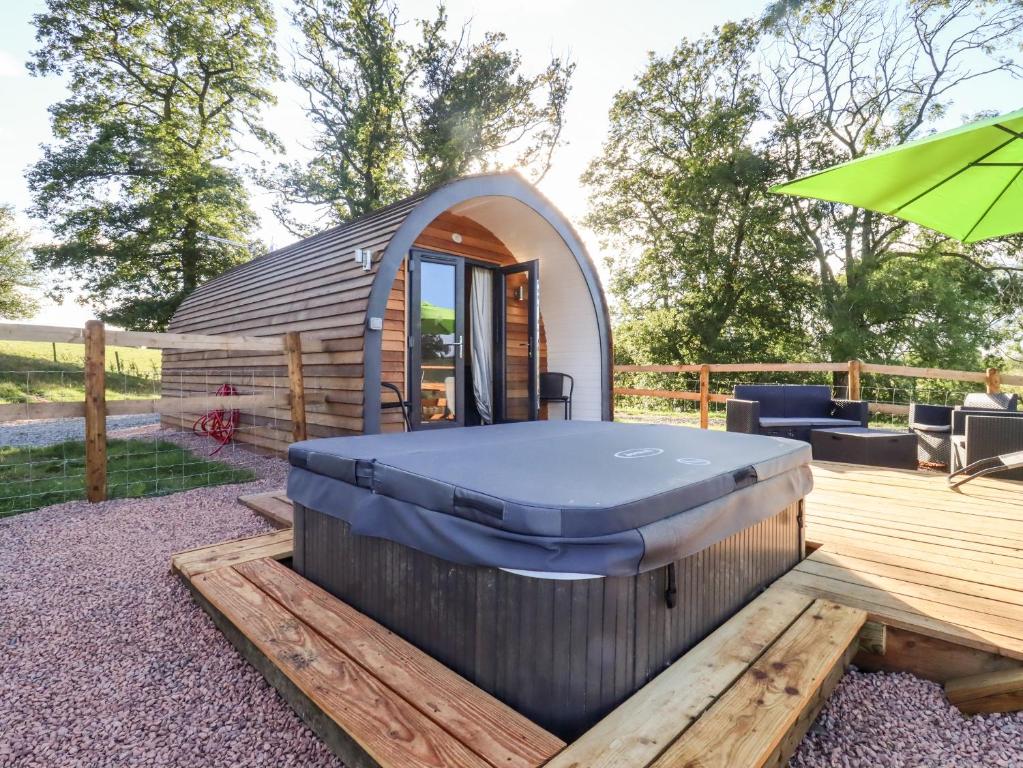 a hot tub on a deck in front of a dome house at Goose Pod in Worcester