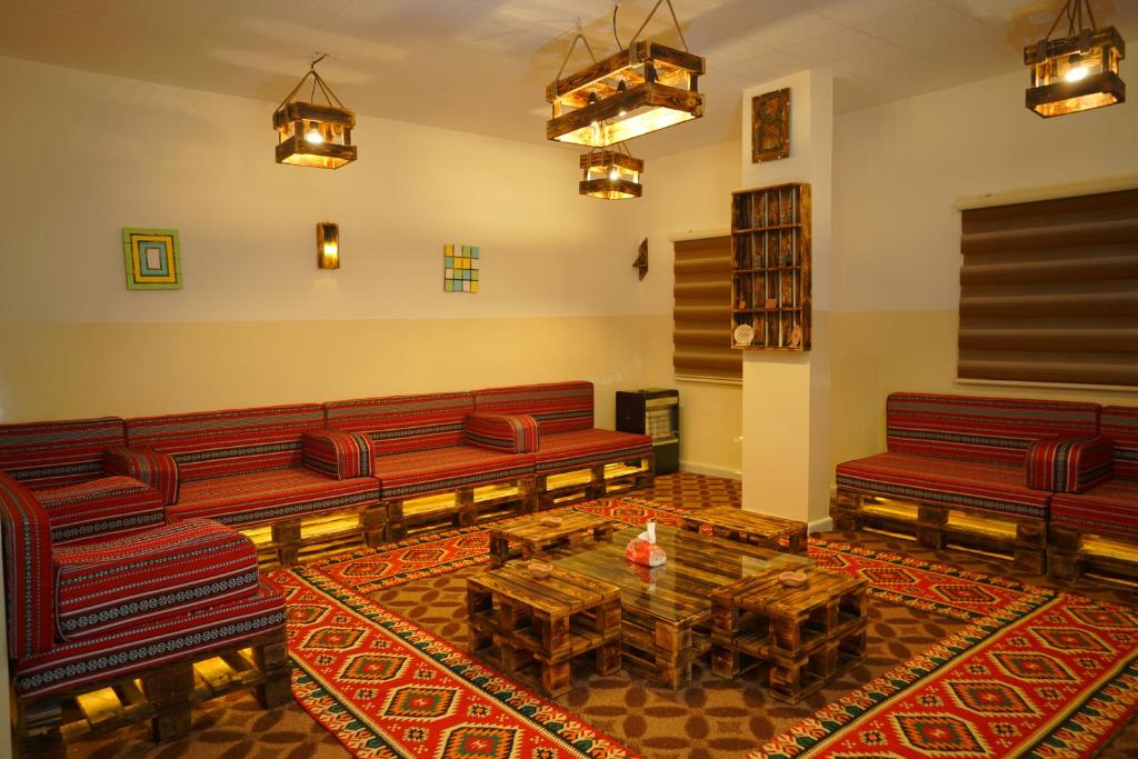 a living room with red benches and a table at Petra Wooden House in Wadi Musa
