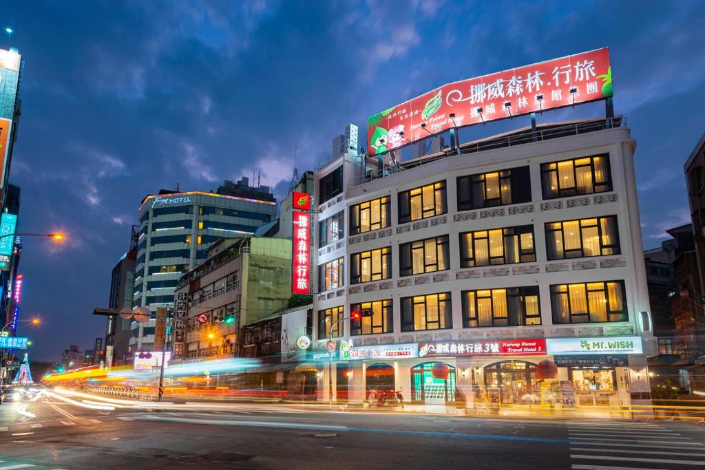 un bâtiment situé dans une rue de la ville la nuit dans l'établissement Norway Forest Travel hotel 3 Taichung, à Taichung