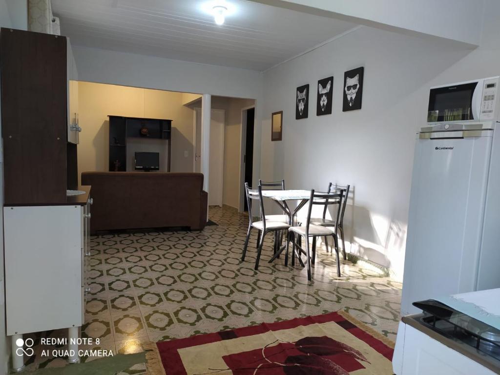 a kitchen with a table and chairs in a room at KITNET DU VÔ in Santa Teresa