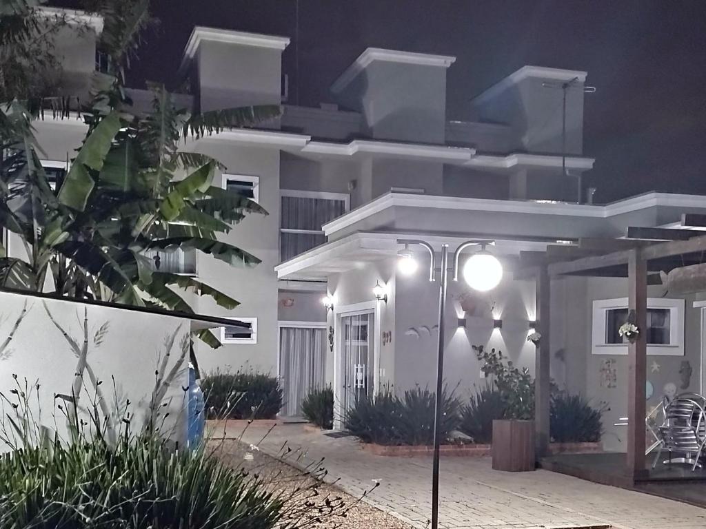 una casa blanca con una luz de la calle delante de ella en Pousada Rota dos Mares en Penha