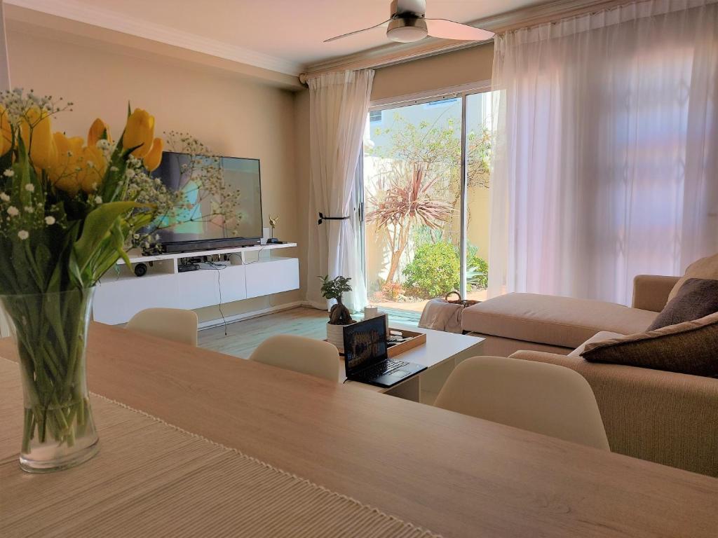 a living room with a vase of flowers on a table at CherryPlum self-catering in Cape Town