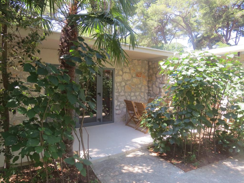 a porch of a house with a palm tree at Camping Mia Bungalow & Mobile Home in Biograd na Moru