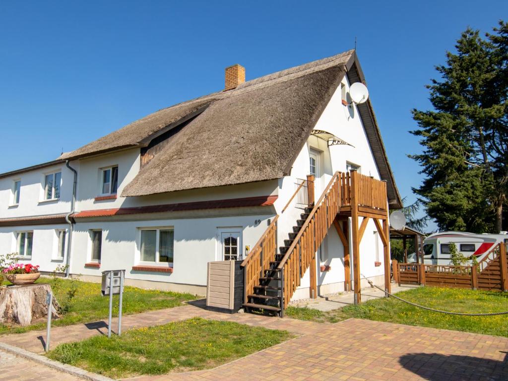 ein großes weißes Haus mit einem Strohdach in der Unterkunft Ferienwohnung Sonnenseite in Freest