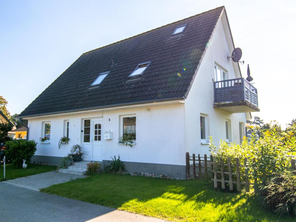 a white house with a black roof at Ferienwohnung Sukow in Freest