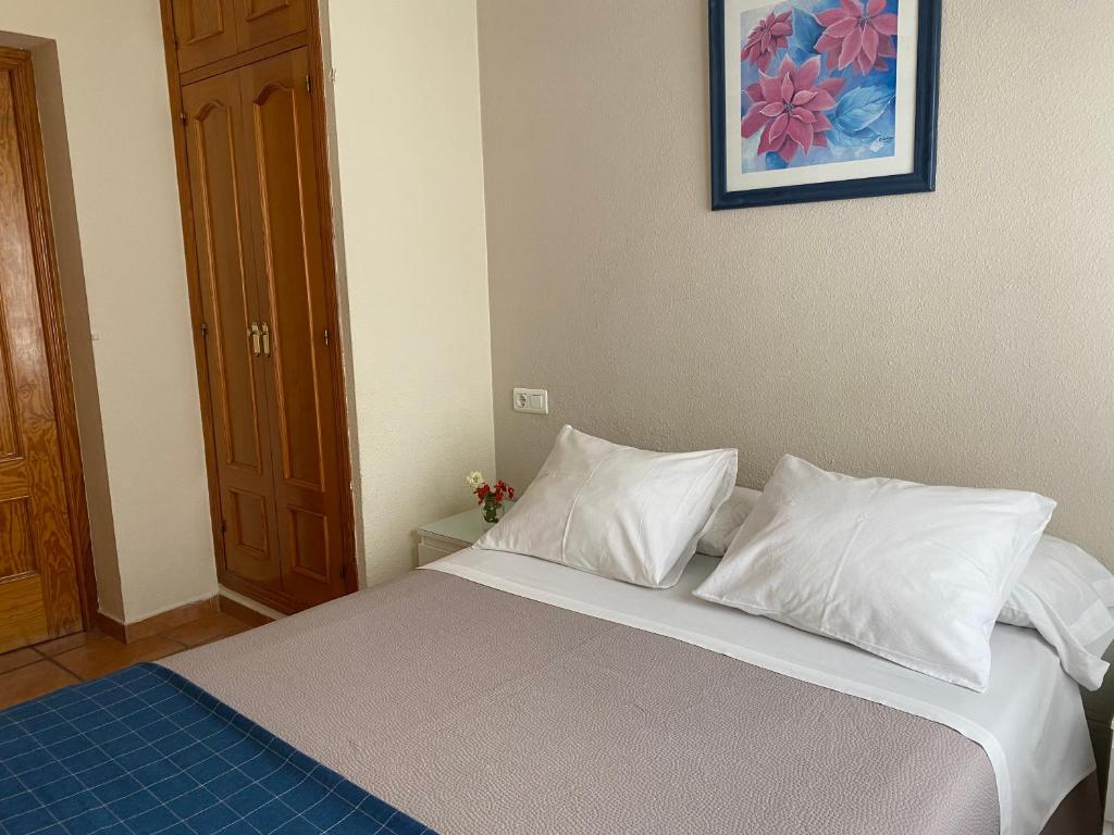 A bed or beds in a room at Hostal Moscatel