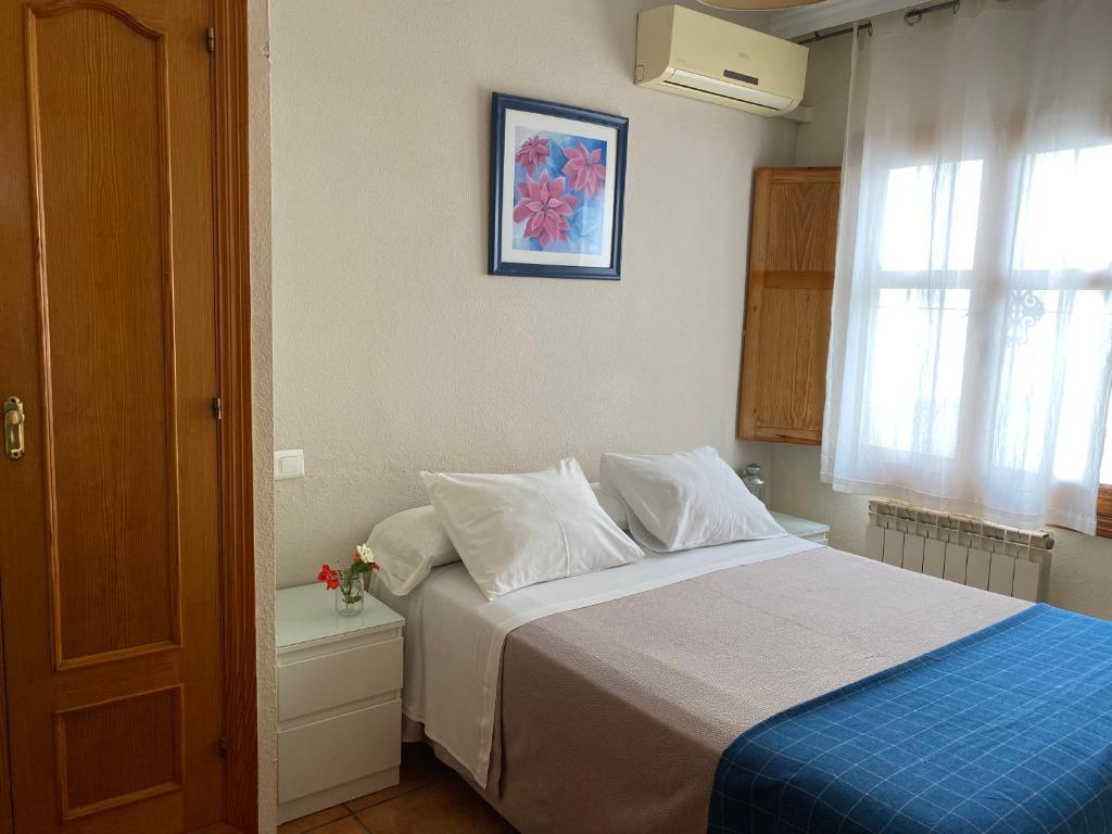A bed or beds in a room at Hostal Moscatel