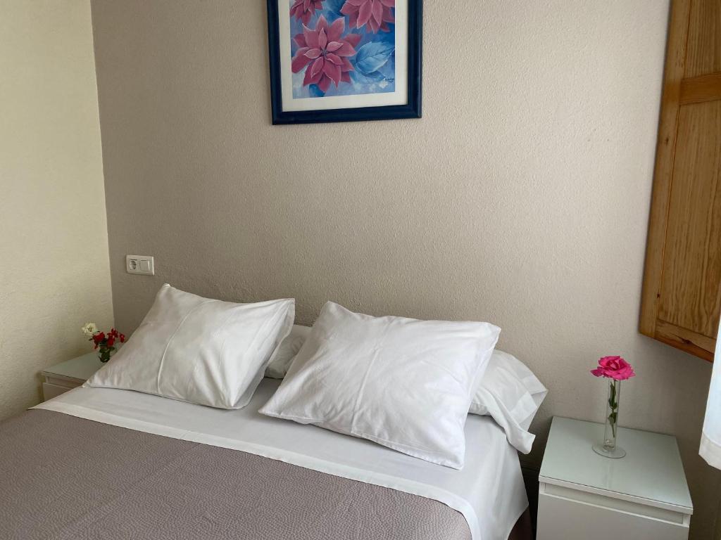 A bed or beds in a room at Hostal Moscatel