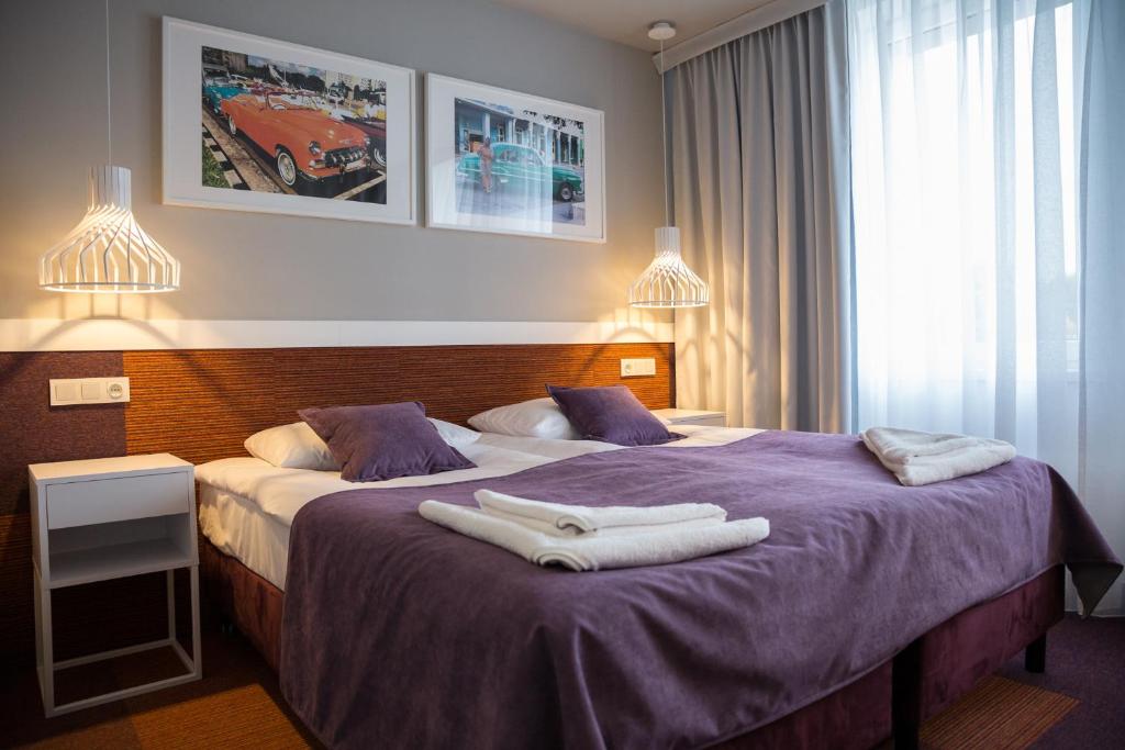 a hotel room with two beds with towels on them at Hotel Quattro in Szczecinek