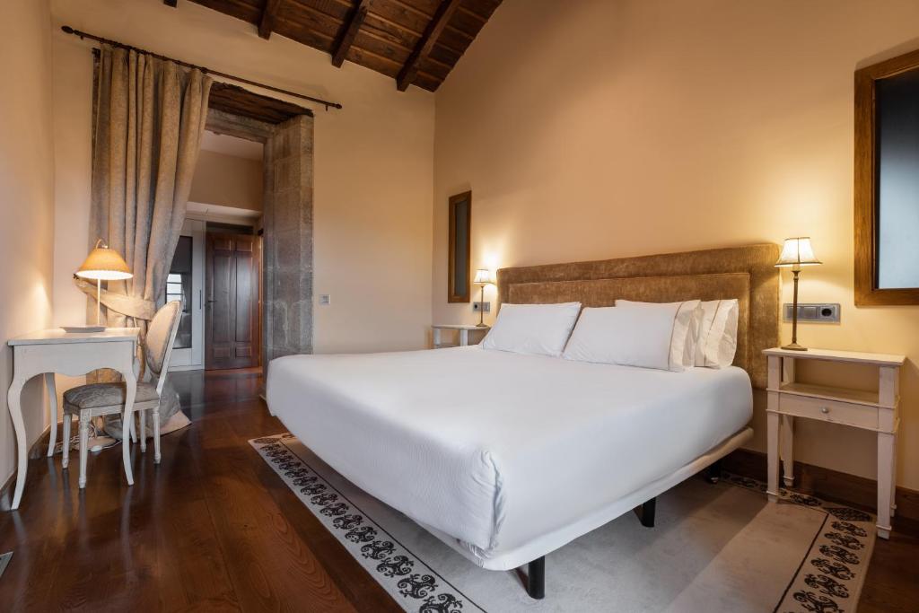 Łóżko lub łóżka w pokoju w obiekcie Áurea Palacio de Sober by Eurostars Hotel Company