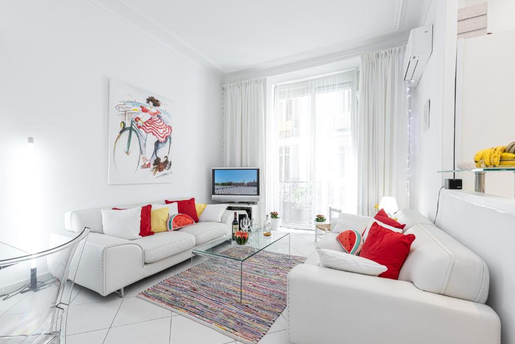 ein weißes Wohnzimmer mit zwei weißen Sofas und einem TV in der Unterkunft FEEL HOME - GRIMALDI in Nizza
