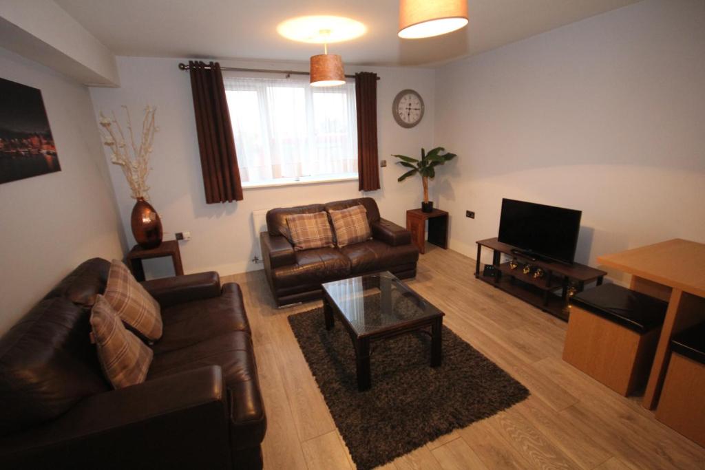 a living room with a couch and a tv at Holden Court Apartments - Apt 3 in West Drayton