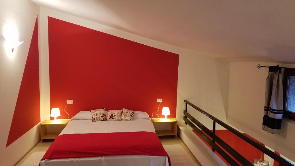 una camera con una parete rossa e un letto di Honeycomb - casa vacanze a Varese