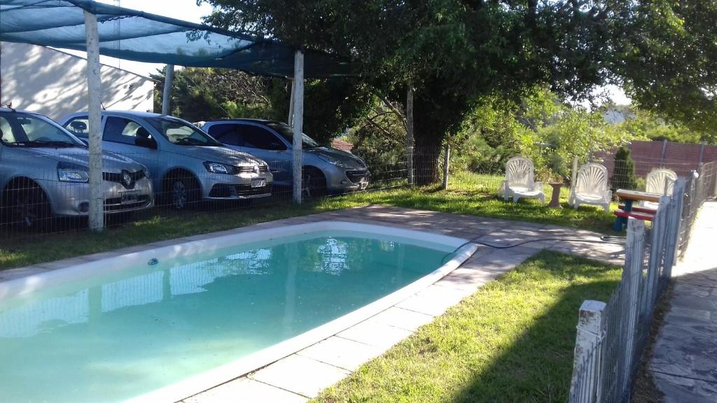 una piscina con dos coches aparcados en un patio en Edificio Astrid en Villa Gesell