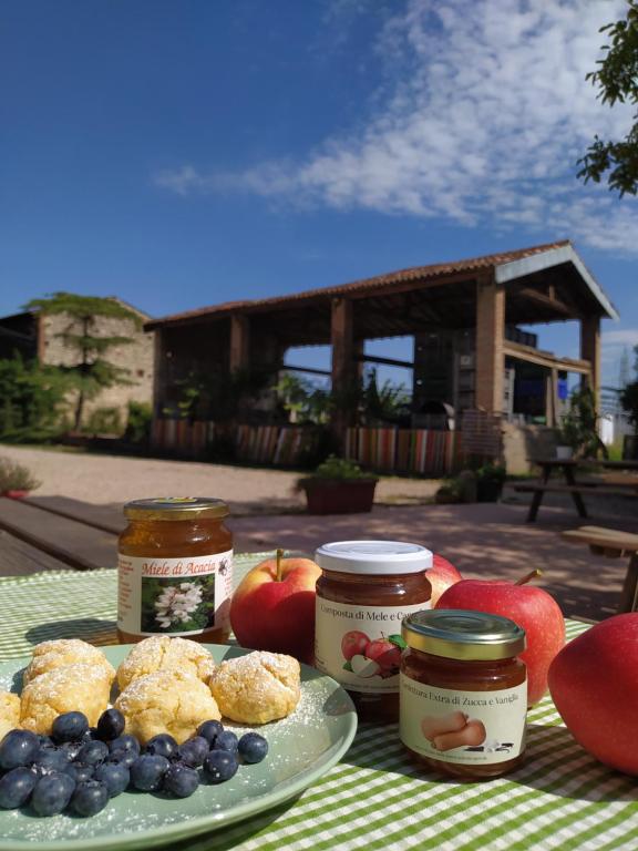 a table with a plate of food and jars of jam at Agriturismo Croce del Gal in Verona