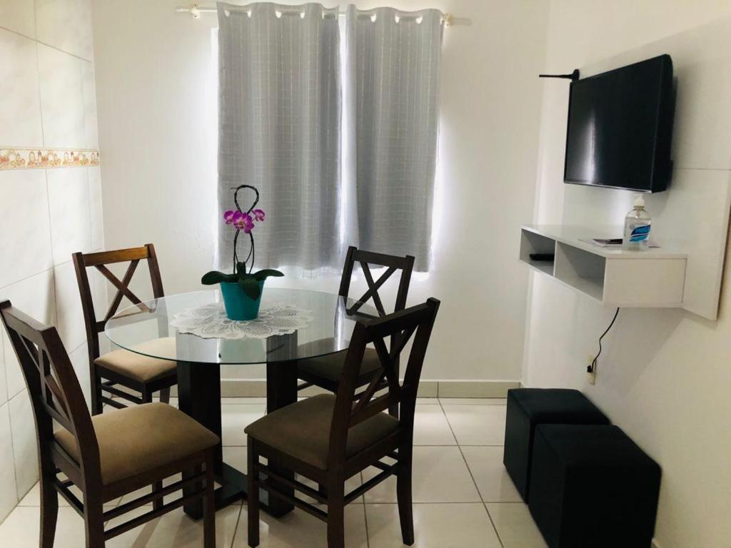 a dining room with a table and chairs and a tv at Apartamento em Floripa -ao lado do Aeroporto e juntinho as praias do Sul da Ilha in Florianópolis
