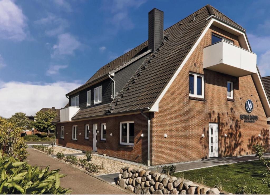 a brick house with a black roof at Astra Maris Apartments in Büsum