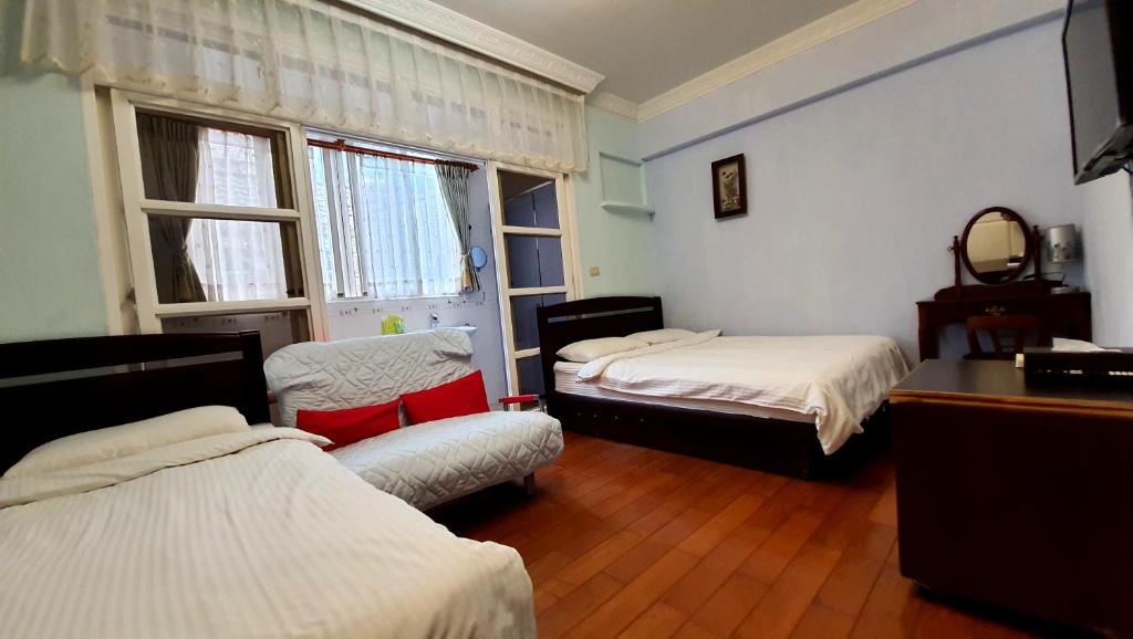 Dongshan River Left Bank tesisinde bir odada yatak veya yataklar