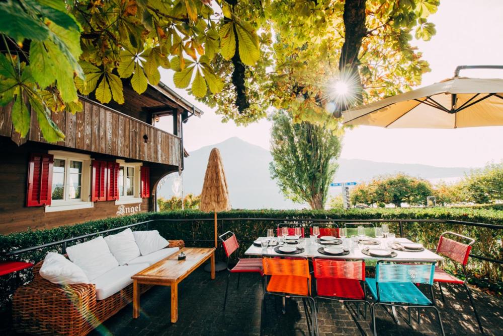 a patio with a table and chairs and a couch at THE BOUTIQUE Gasthaus Engel in Walchwil