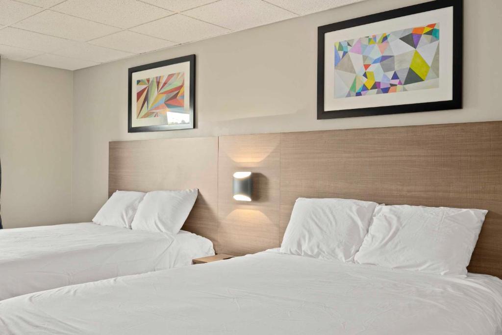 2 camas en una habitación de hotel con sábanas blancas en The Elmwood en Waterville