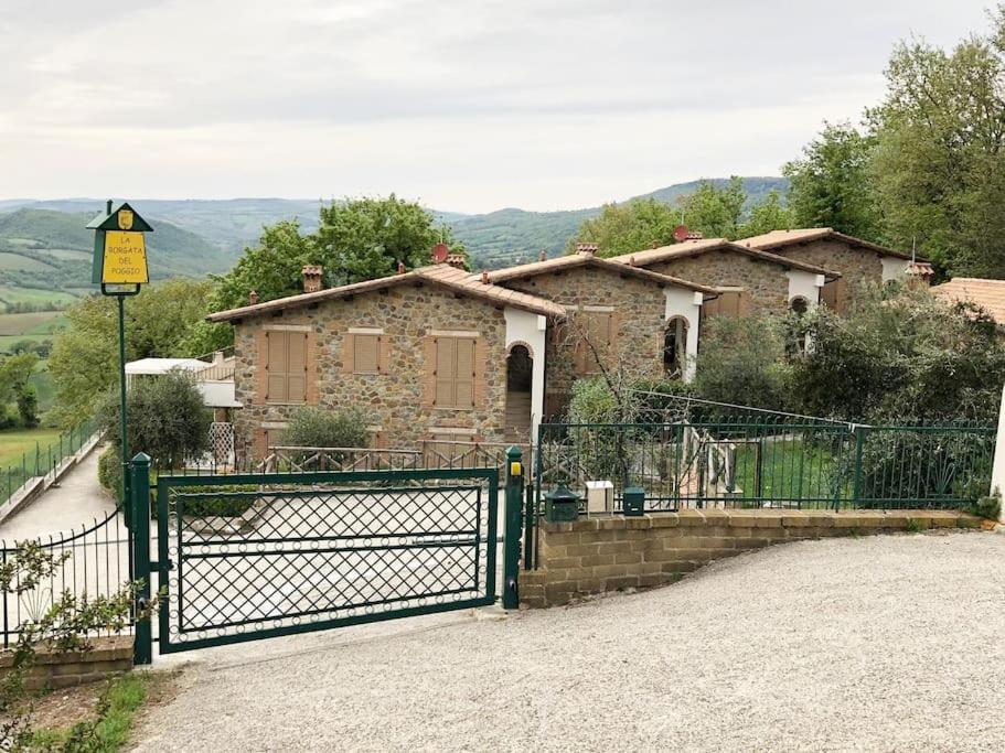 a green fence in front of a house at Il Poggio da Leo in Capanne