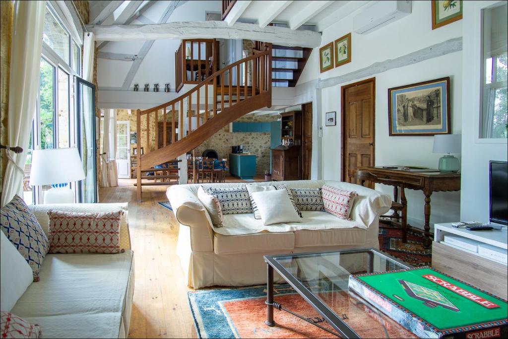 un salon avec un canapé et un escalier dans l'établissement la grange de pyraine, à Issac