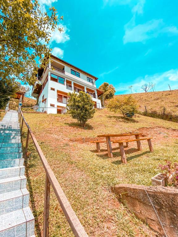 a picnic bench in front of a building at Pousada Cantinho da Montanha 2 in Visconde De Maua