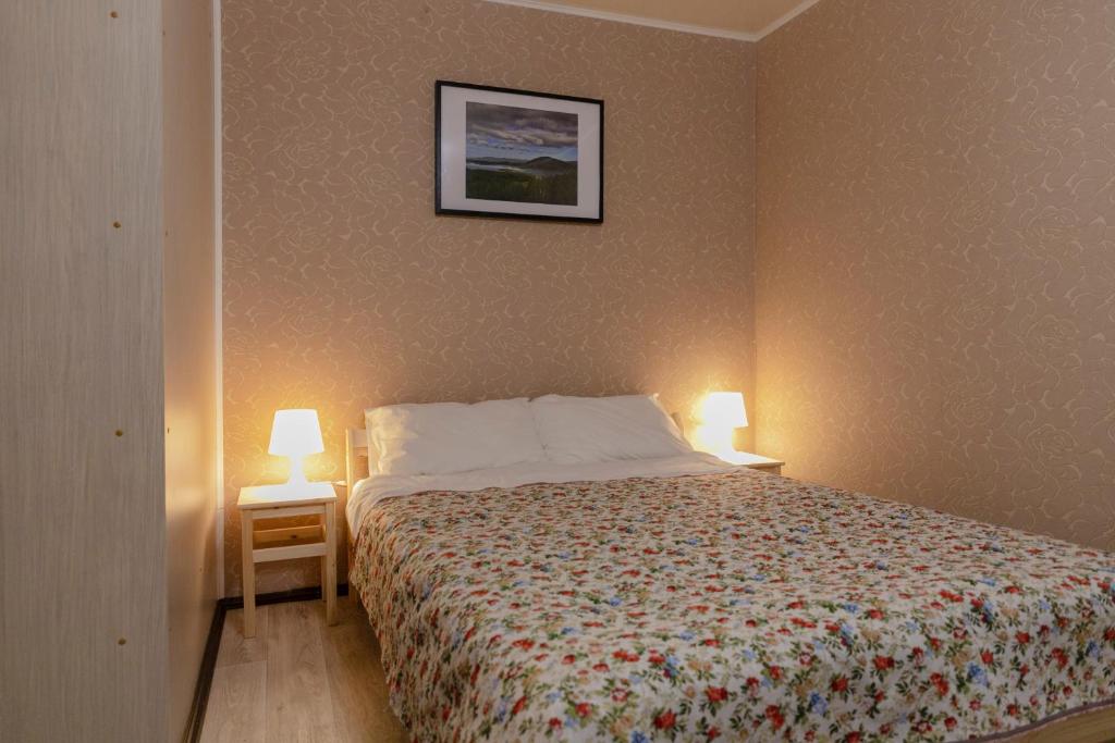 sypialnia z łóżkiem z dwoma lampami po obu stronach w obiekcie Apartment Ural on Evteeva 5 w mieście Czelabińsk