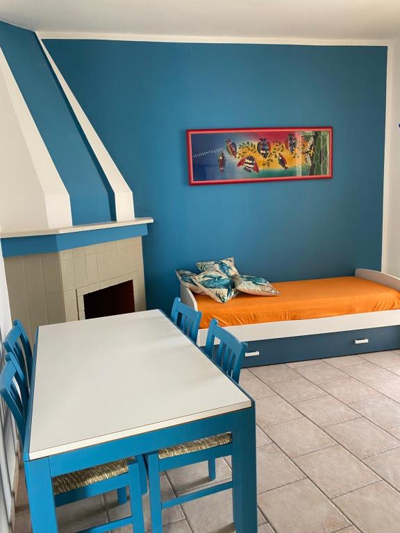 una camera con letto, tavolo e sedie di casa patrizia a Villanova