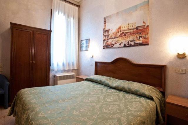 a hotel room with a bed and a window at Hotel Florida in Venice