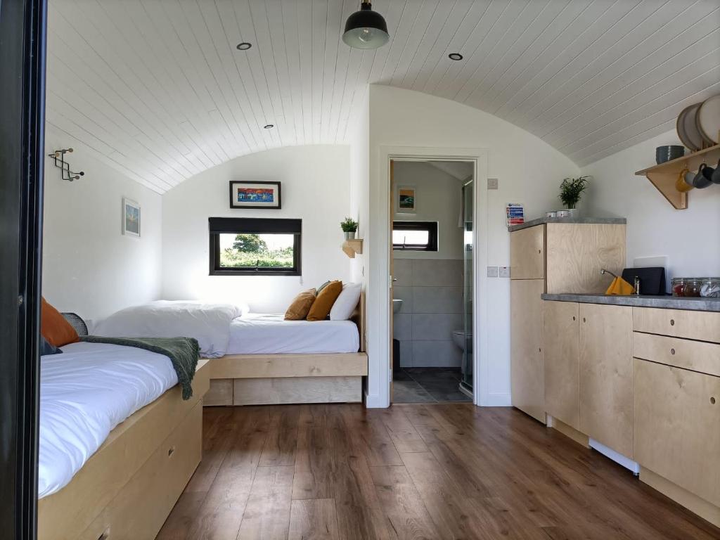 a bedroom with two beds and a kitchen at Castledarcy Glamping in Lahinch