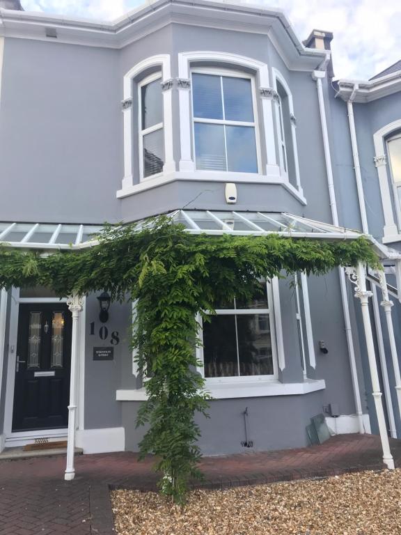 a white house with ivy on the front door at Wisteria house in Plymouth