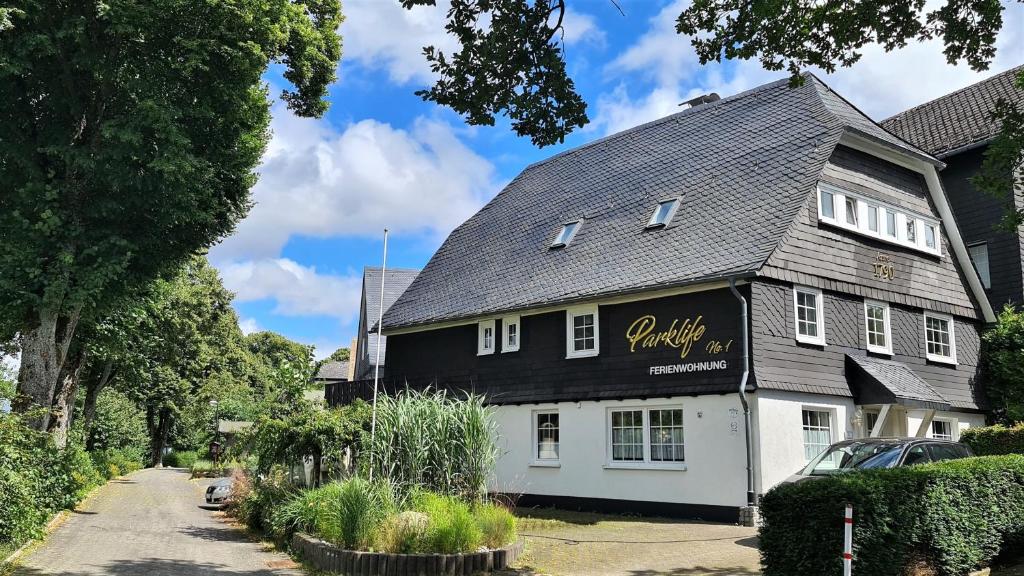 a black and white building with a sign on it at Parklife Apartments in Winterberg