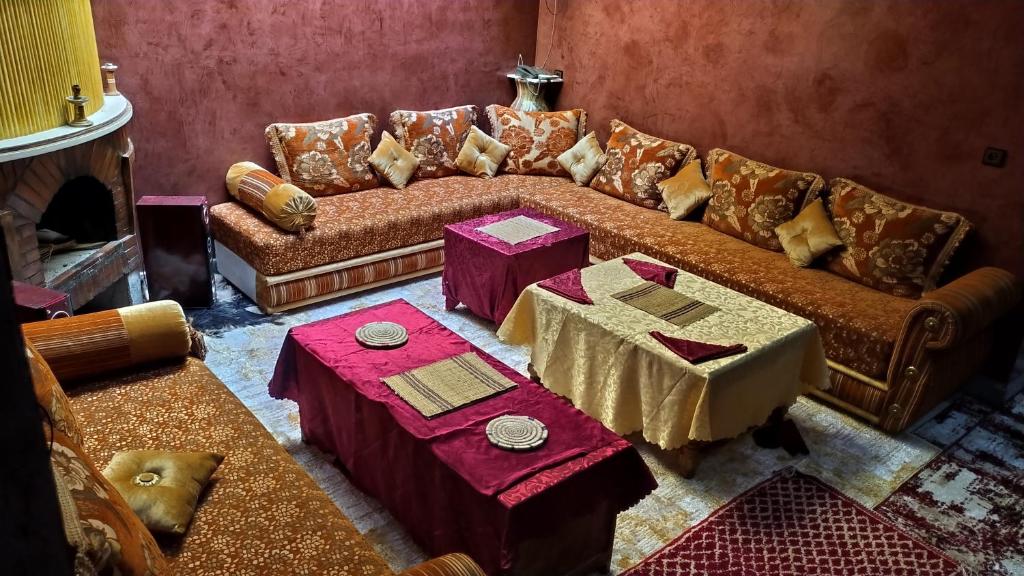een woonkamer met een bank en een tafel bij Dar Calme Chez El Bouhali in Skoura