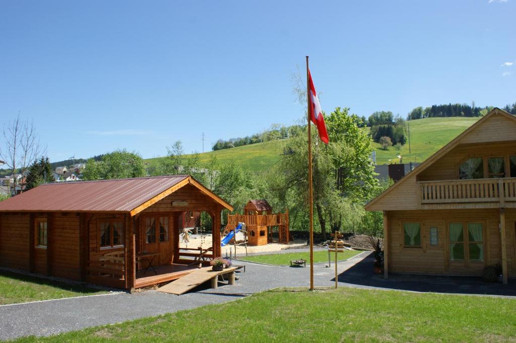 uma cabana de madeira com uma bandeira à sua frente em Villa Donkey Chalet em Degersheim
