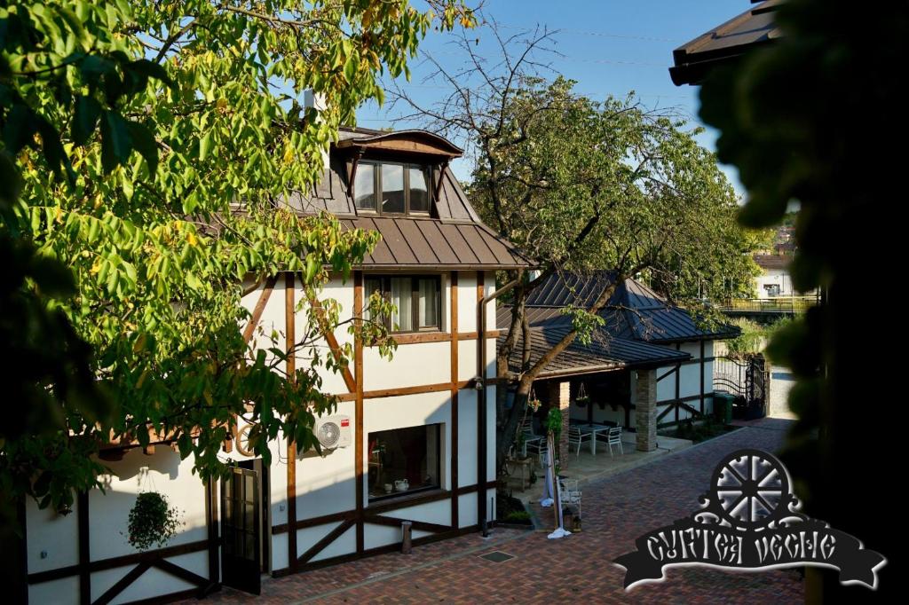 - une vue sur un bâtiment avec un arbre dans l'établissement Curtea Veche, à Hunedoara