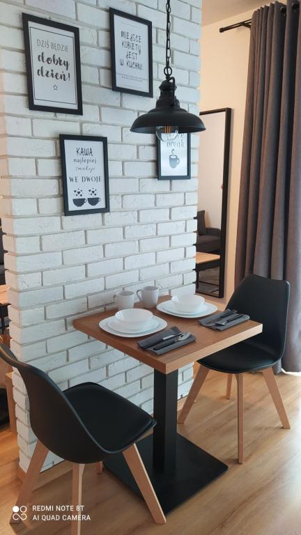 a dining room table with two chairs and a table and chairs at Apartament dla Dwojga - Apartament typu studio in Dziwnówek