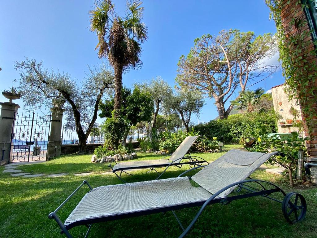 zwei Liegestühle im Gras im Hof in der Unterkunft Casa vacanze Gabbianella villa con giardino lungolago Maderno in Toscolano-Maderno