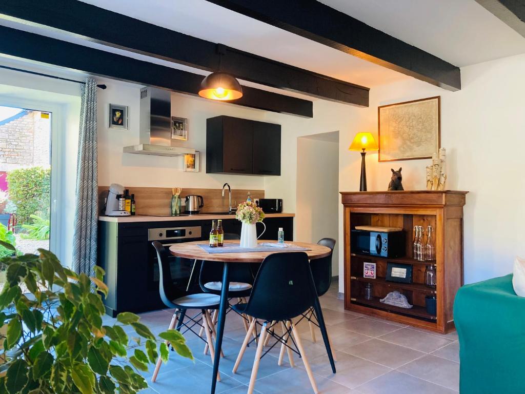 a kitchen with a table and chairs in a room at Charmante petite maison rénovée in Quistinic
