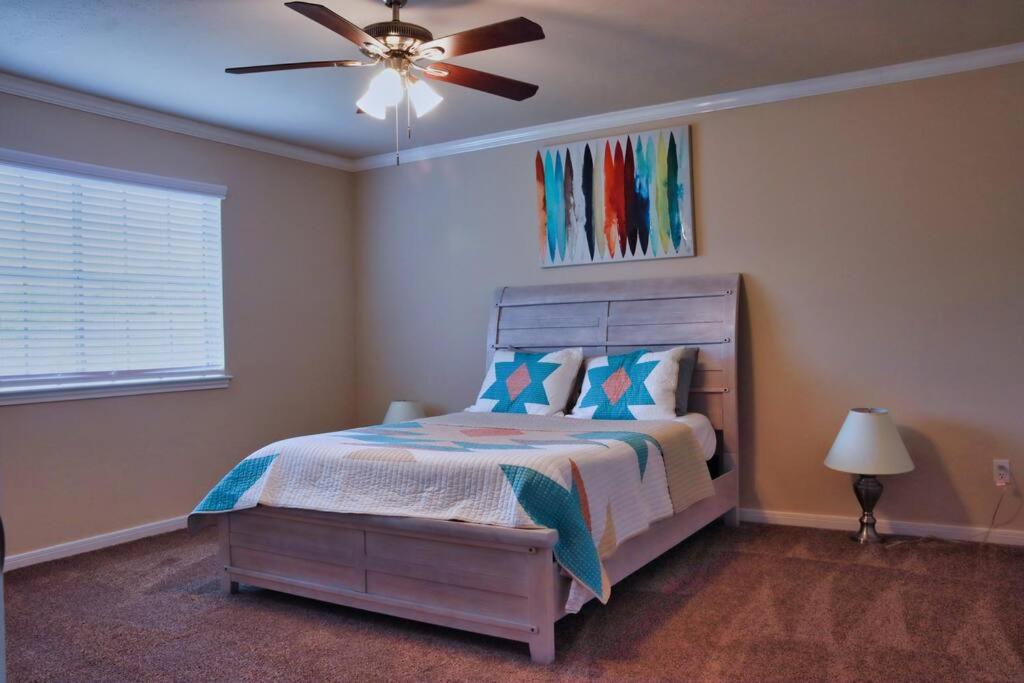 um quarto com uma cama e uma ventoinha de tecto em North of Houston! Everything you need!! - Coral Ridge em Houston
