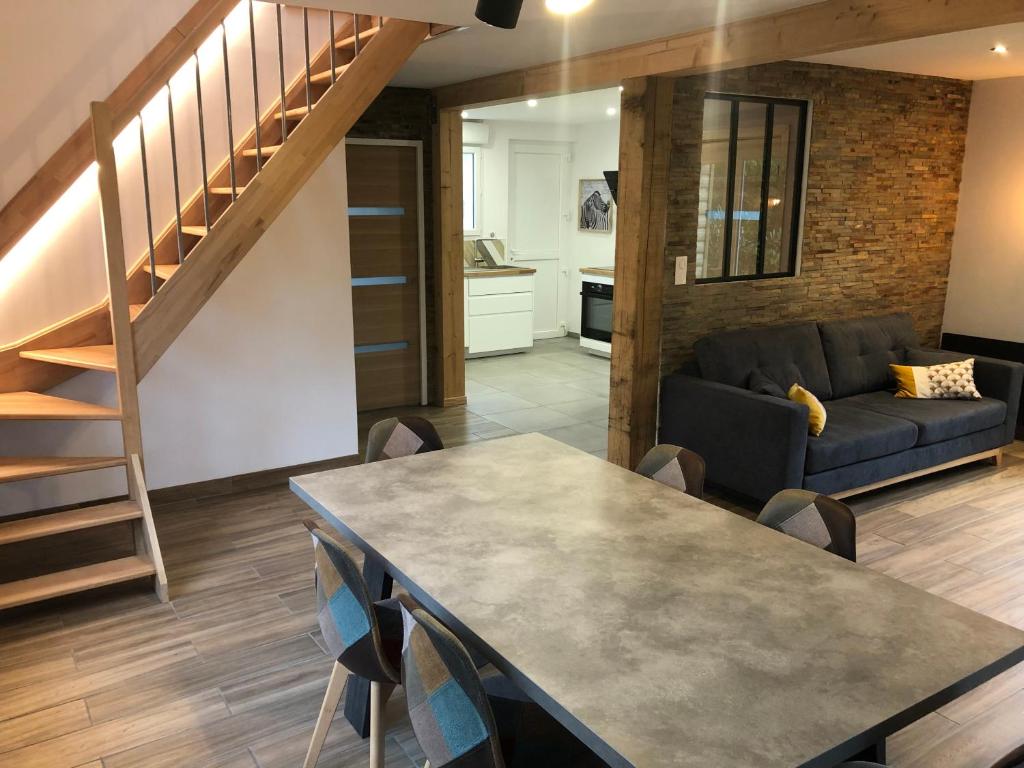 a living room with a table and a couch at Maison cosy entièrement rénovée in Aumale