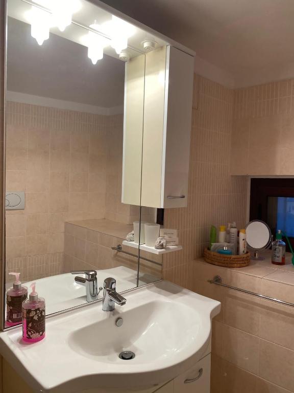 łazienka z białą umywalką i lustrem w obiekcie Casa Lucilla w mieście Pizzo