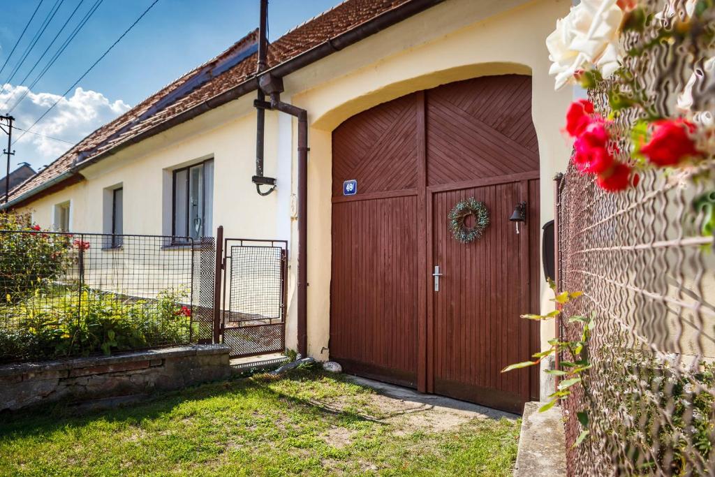 una casa con una puerta de madera en un patio en Chalupa Těšínov en Protivín