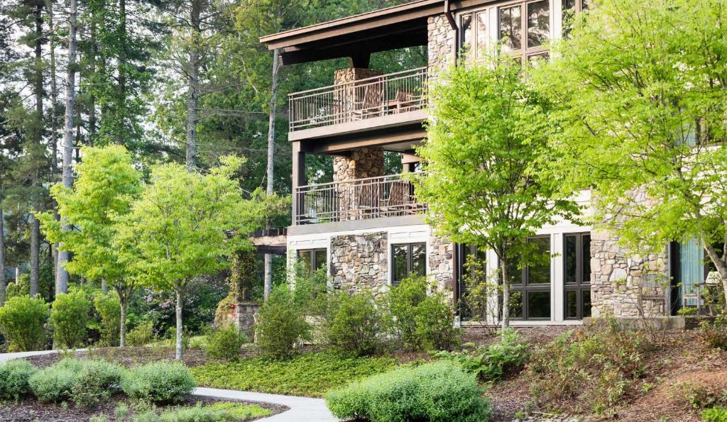 a house with a balcony in the middle of trees at Kanuga Inn & Lodging in Hendersonville