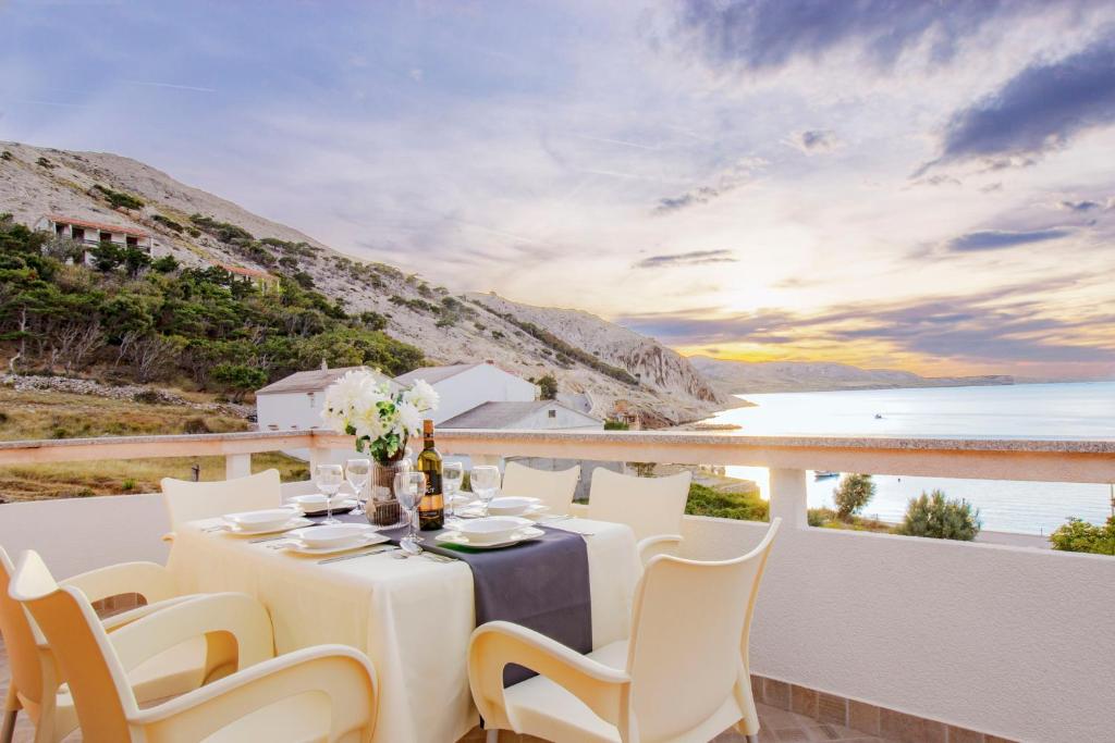 uma mesa e cadeiras numa varanda com vista para o oceano em Sladana direckt at the Beach em Metajna