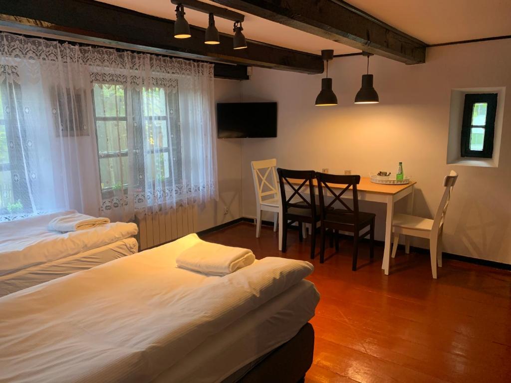 グロジスク・マゾビエツキにあるOjcówekのベッドルーム1室(ベッド2台、テーブル付)、ダイニングルームが備わります。