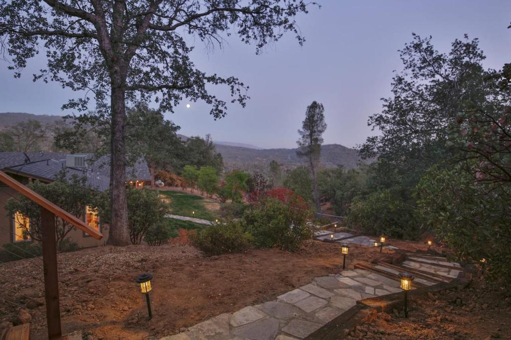 a home with a view of a garden with lights at Whispering Pines Lookout in Oakhurst