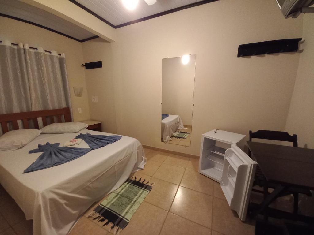um pequeno quarto com 2 camas e um espelho em Pousada Girar do Sol em Nova Friburgo