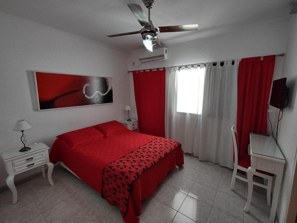 1 dormitorio con cama roja y ventana en Costa Bonita en Colón